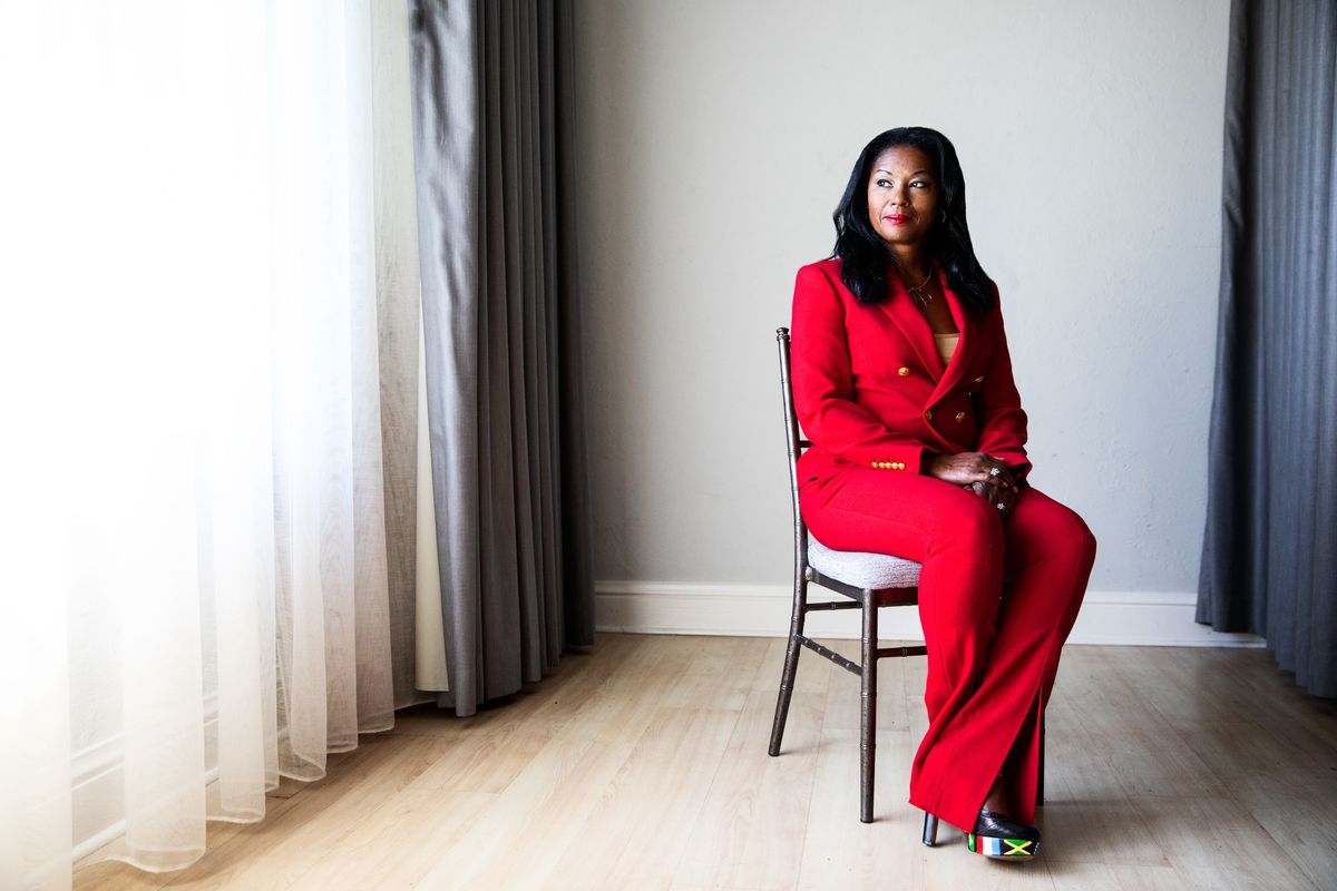 Kimberly G. Jackson seated in a red suit in an editorial setting