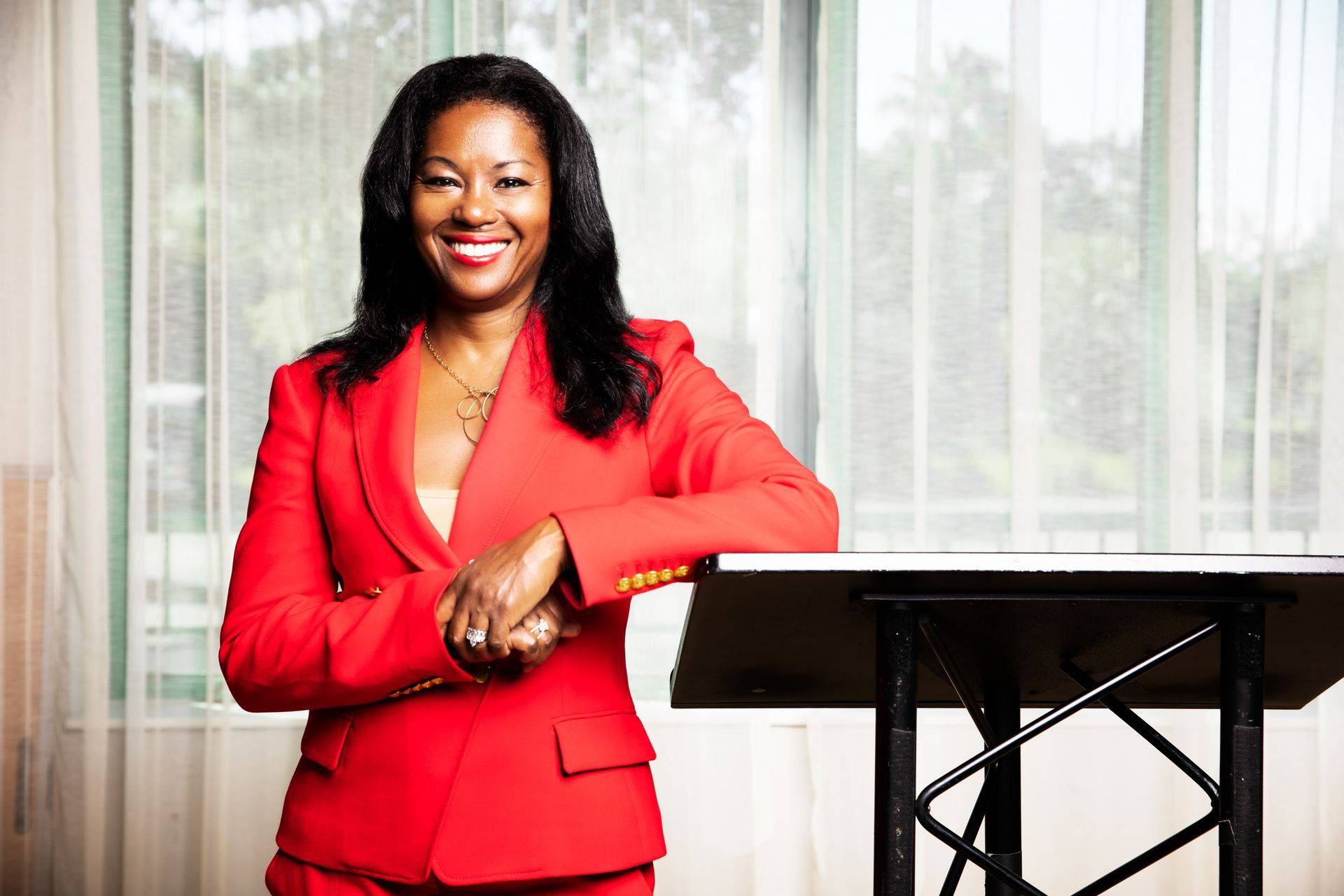 Kimberly G. Jackson speaking at a podium in a red suit